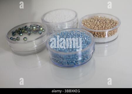 Colorful Glass Seed Beads in Transparent Plastic Containers on White Background Stock Photo