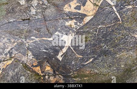 Natural rock formation showcasing complex patterns and fractures. Stock Photo