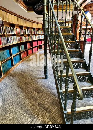 Ornate curved metal stairs with curved bookcases and books in Liverpool Central Library Picton Reading Room. Editorial, 17 May 2025. Stock Photo