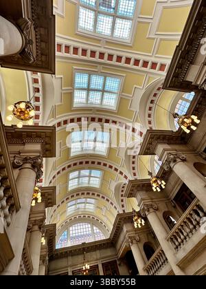 Interior of Hornby Library in Liverpool Central Library showing ornate ceiling, stone pillars, and balustraded balcony. No people visible. Stock Photo