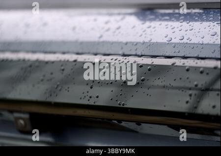 A fragment of a car. Raindrops on a blue car. Close-up. Stock Photo