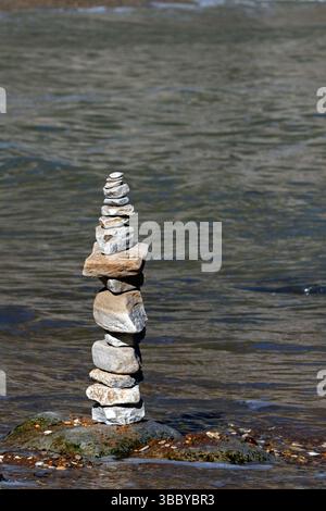 Cairn on a beach with the tide coming in. Stock Photo