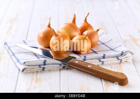 Organic yellow onions on a wooden table, selective focus. Stock Photo
