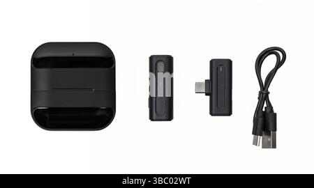 Wireless microphone kit with USB-C receiver, charging case, and USB cable isolated on white background. Stock Photo