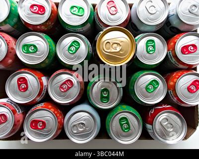A box of soda cans with a green can in the middle. The green can is the only one that is not red, green, or blue Stock Photo