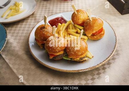 Mini burgers and fried potatoes on the table at party food. Finger food on catering Stock Photo