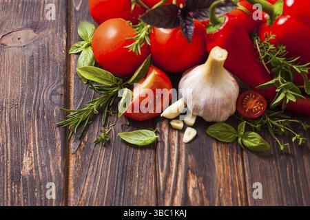 Closeup of various fresh vegetables together with fragrant herbs arranged and on the wooden background with place for copyspace Stock Photo