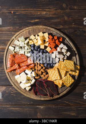Top view of various salty snack on a round wooden stand Stock Photo