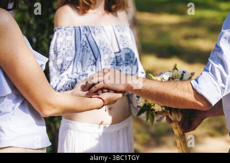 Eclectic wedding couple under the flower arch. Rustic and hippie style pair Stock Photo