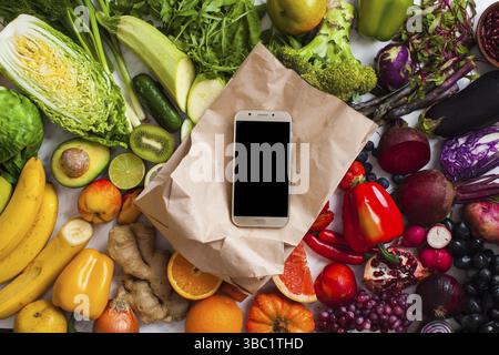 Farm products, smartphone on the paper bag - delivery concept, zero waste package. Local market food with vegetables and fruits Stock Photo