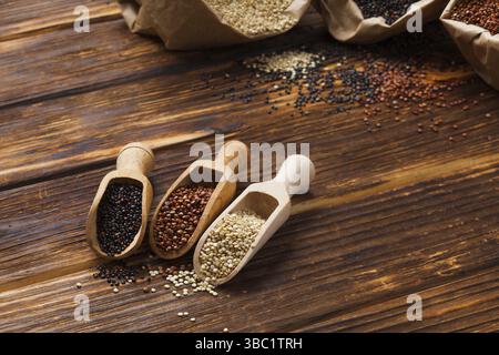 Seeds of white, red and black quinoa in wooden scoops close up Stock Photo