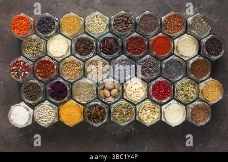 Different kinds of spices and herbs in glass on grey background, top view Stock Photo