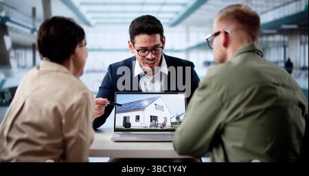 Hispanic Real Estate Broker Consulting Young Couple In Computer Market Stock Photo