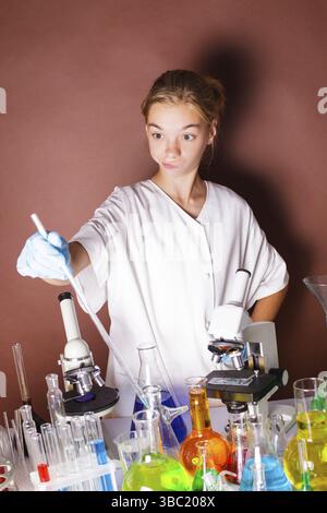 Schoolgirl is standing near blackboard and doing very important researche Stock Photo