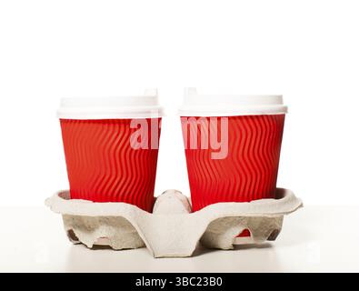 Disposable red paper coffee cups of different sizes standing in a row on a white background, mockup for design for espresso, cappuccino, latte Stock Photo