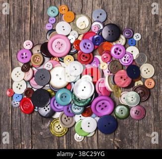 Colorful buttons heap on a wooden background Stock Photo