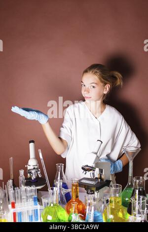 Schoolgirl is standing near blackboard and doing very important researche Stock Photo