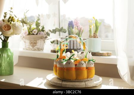 Easter decorations - textile basket with rabbits and eggs, morning light from window Stock Photo