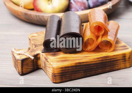 Dry fruit leather on the wooden board, plum and apple Stock Photo
