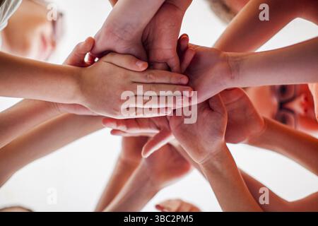 Close up children hands together, view from down. Friendship, partnership and teamwork concept Stock Photo
