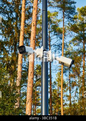 Multiple Surveillance Cameras Mounted on Pole in Forest Area Stock Photo