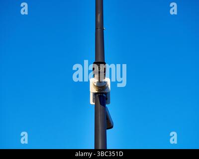 Modern Surveillance Camera on a Pole Against Clear Blue Sky Stock Photo