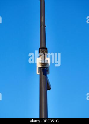 Modern Surveillance Camera on a Pole Against Clear Blue Sky Stock Photo