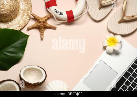 Frame made of laptop with flip flops and beach decor on beige background Stock Photo
