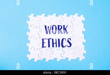 Puzzle with the word work ethics written on it. The puzzle is made up of white pieces Stock Photo