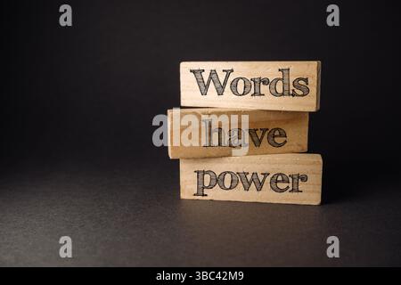 Three wooden blocks with the words words have power written on them. The blocks are stacked on top of each other Stock Photo