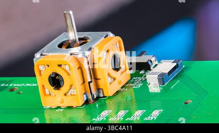 Close-up of joystick axis analog sensor module on green PCB. Yellow 3D control thumb stick or connector, switch and surface mounted LED light diodes. Stock Photo