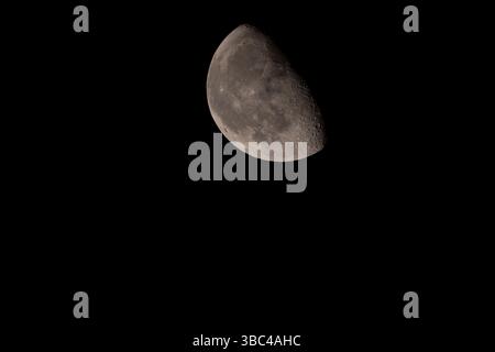 Detailed view of the waxing gibbous Moon against a black night sky. Surface craters and texture are clearly visible in this high-resolution astronomic Stock Photo