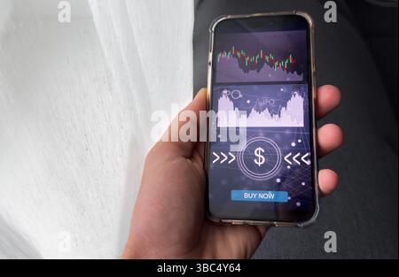 Businessmen work with stock market investments using smartphone to analyze trading data. smartphone with stock exchange graph on screen. Financial Stock Photo