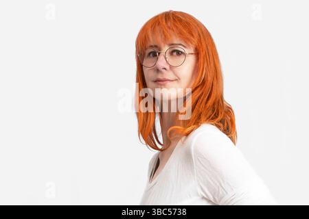 Portrait of a red-haired woman in front of an orange autumn landscape Stock Photo