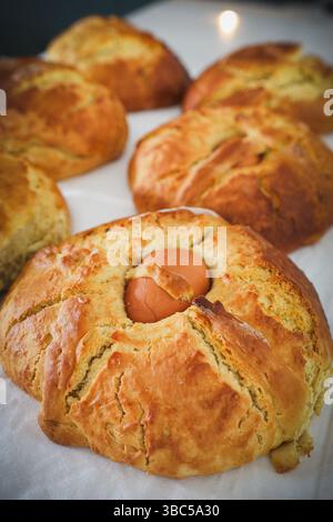 Close-up of freshly baked folar, a traditional Portuguese Easter bread with a whole egg in the center, symbolizing rebirth and celebration Stock Photo