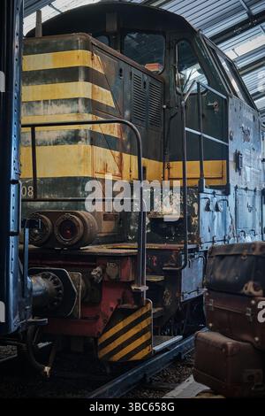 Aged industrial diesel locomotive 7408 Uranus (1977) with faded paint and rusty details on display in a railway museum in Belgium, evoking vintage ind Stock Photo