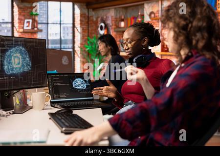 Teamworking startup technicians cooperating to do rapid technological advancement in AI industry. Silicon Valley company colleagues leveraging deep learning tech in workspace to gain competitive edge Stock Photo