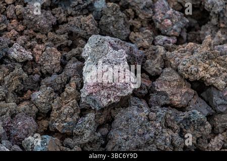 Lava rocks cover the ground on the Avenida Marítima in El Golfo, Lanzarote. The different textures and colours of the rocks show the different cooling and crystallisation patterns of the lava. Avenida Marítima, El Golfo, Canarias, Spain Stock Photo