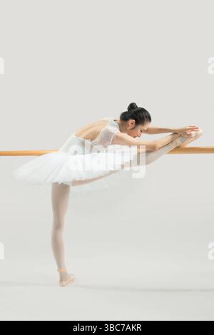 a ballet dancer practicing at the barre​ Stock Photo