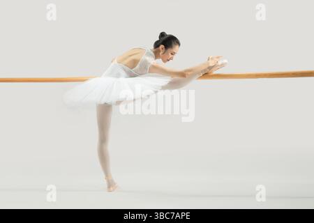 a ballet dancer practicing at the barre​ Stock Photo