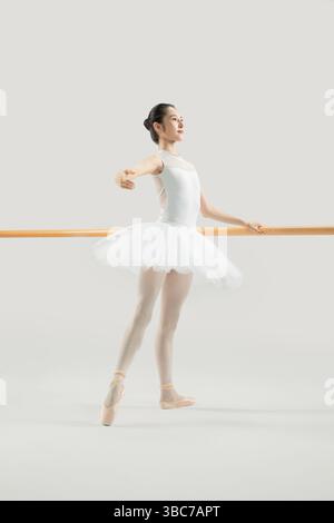 a ballet dancer practicing at the barre​ Stock Photo
