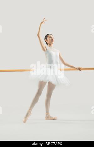 a ballet dancer practicing at the barre​ Stock Photo