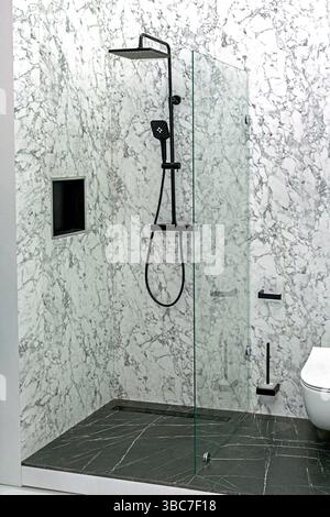 Empty clean shower with ceramic tiles and glass door in modern bathroom Stock Photo
