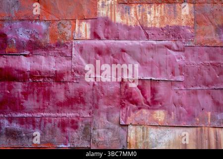 Rusty red painted metal background texture - metal sheets covering a wall of an old industrial building Stock Photo