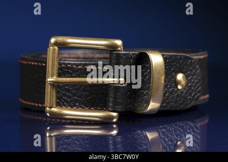 Black leather belt on a dark blue background Stock Photo