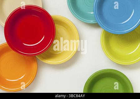 Colorful ceramic bowls on white tablecloth - top view Stock Photo