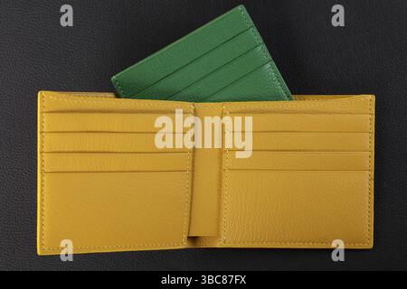 Leather products. Wallet business card holder made of green and yellow genuine leather on a black background Stock Photo