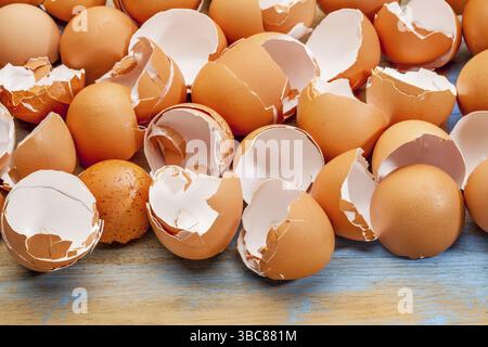Empty, broken, brown eggshells against wooden background Stock Photo