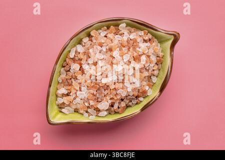 Coarse crystals of pink Himalayan salt in ceramic leaf shaped bowl, top view Stock Photo