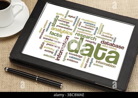 Data and information data cloud on a digital tablet with a cup of coffee Stock Photo